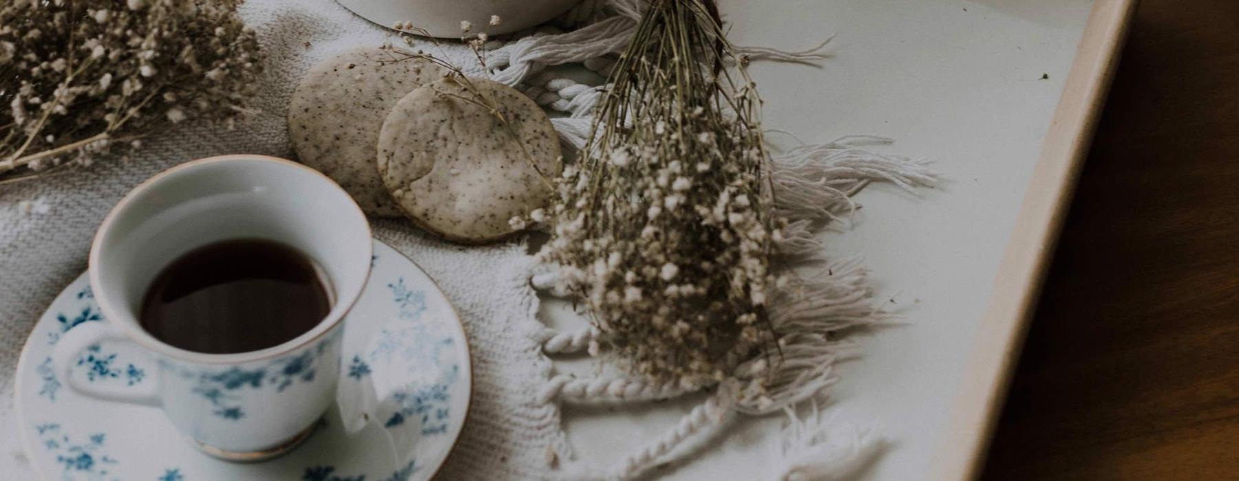 tea and cookies on a serving tray with baby's breath